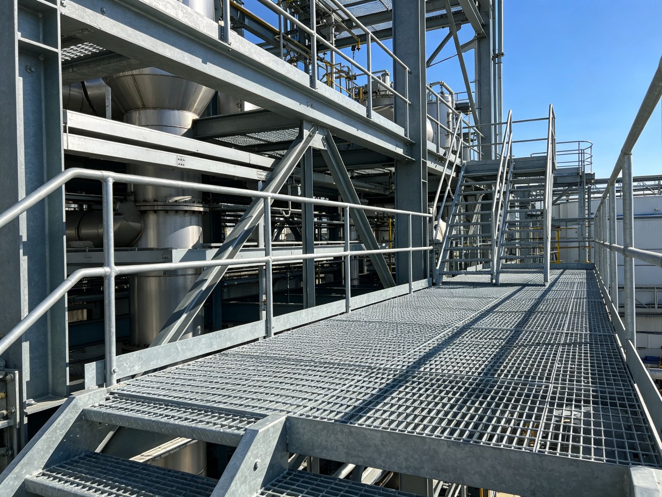 Galvanized steel grating access platform and walkway with handrails and stairs in a process plant