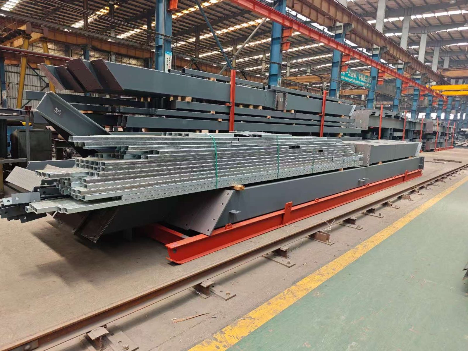 Finished steel members stacked in the yard with part numbering
