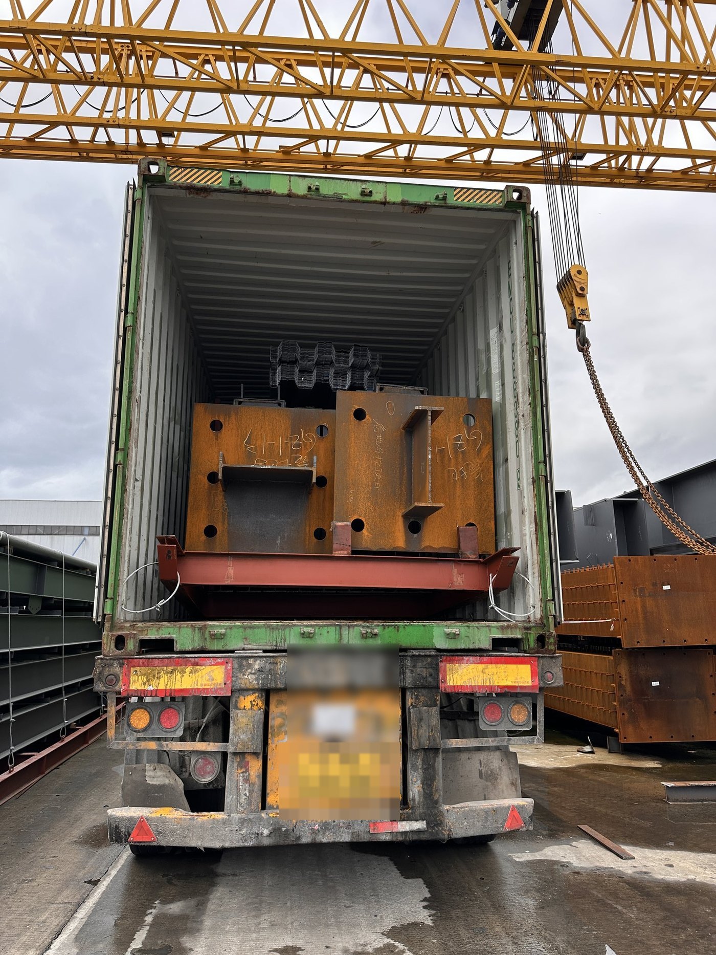 Marked steel components being loaded into a shipping container